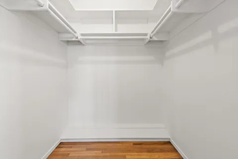 a view of walk in closet with empty racks