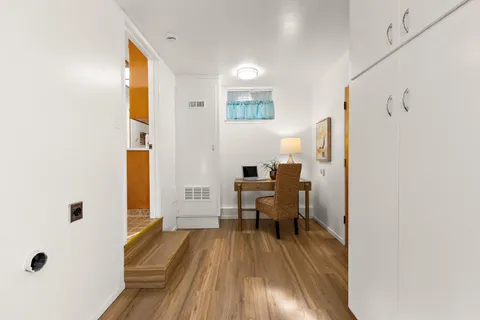 a view of a livingroom with wooden floor and furniture