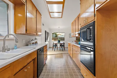a kitchen with a sink refrigerator and cabinets