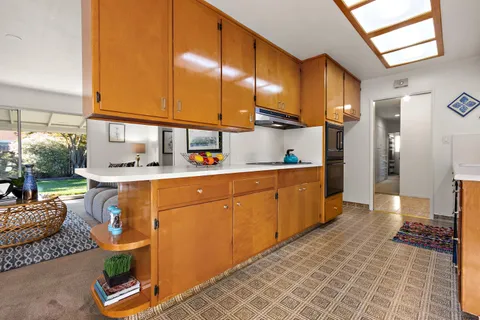a kitchen with stainless steel appliances granite countertop a refrigerator a stove and a wooden cabinets