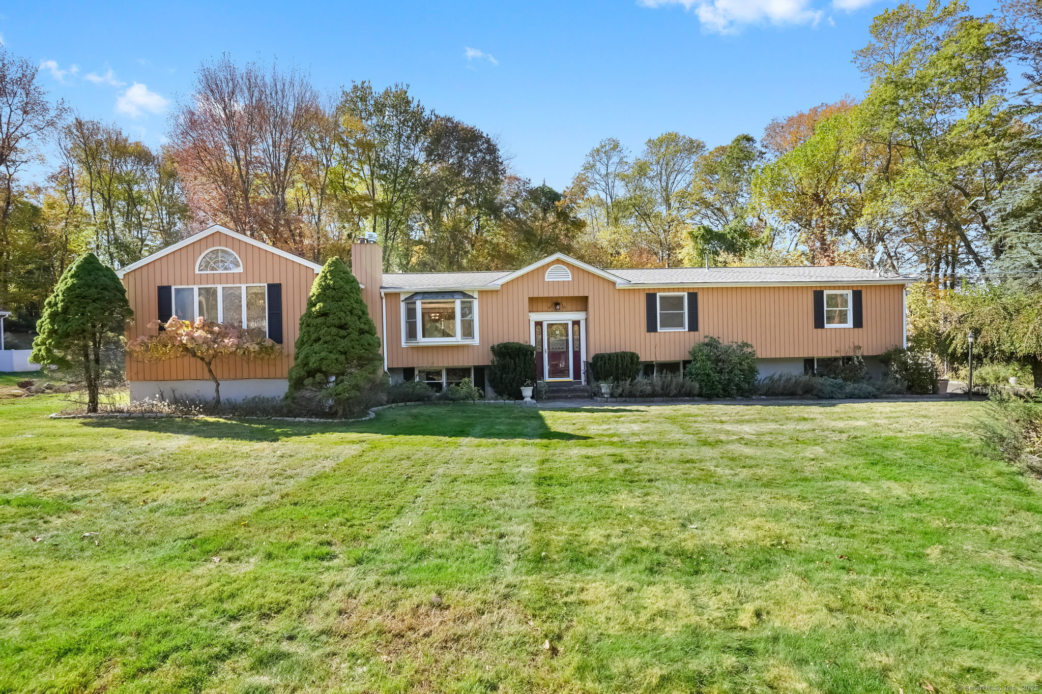a front view of a house with a garden and trees