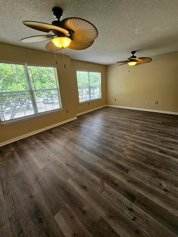 a view of a room with a window and hardwood floor