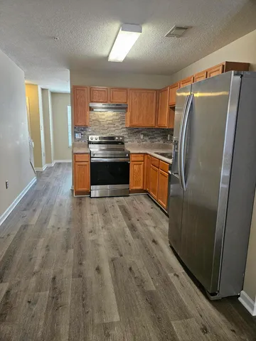 a kitchen with granite countertop a refrigerator and a sink