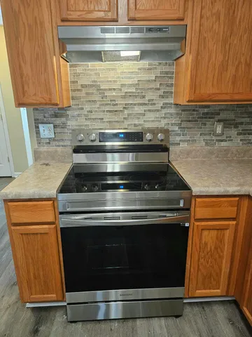a stove top oven sitting inside of a kitchen