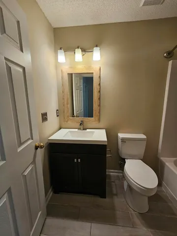 a bathroom with a sink vanity mirror and toilet