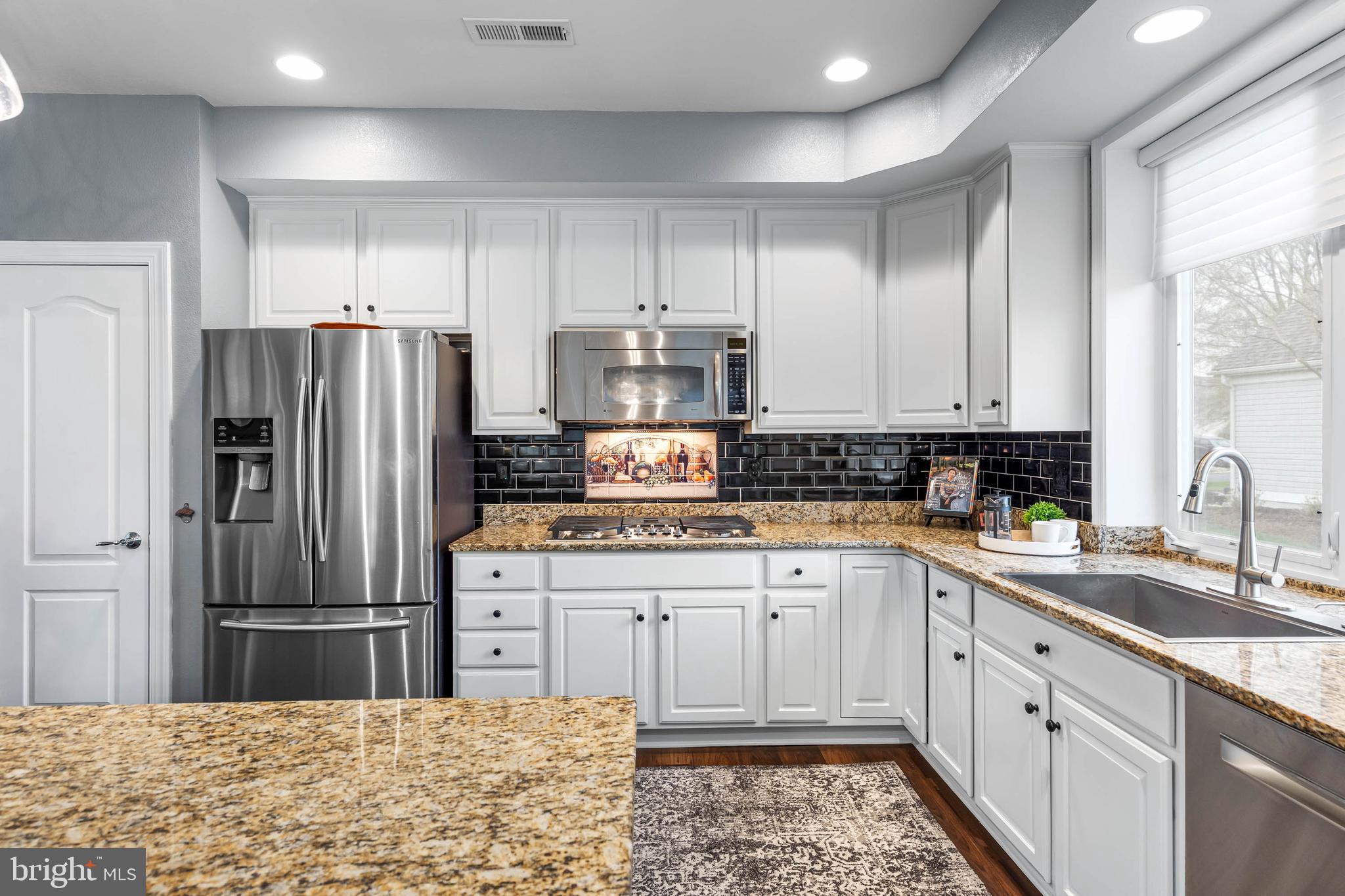 20718 Annondell Drive Lewes, DE 19958 - Photo 12 of 46 a kitchen with stainless steel appliances granite countertop a refrigerator sink and cabinets