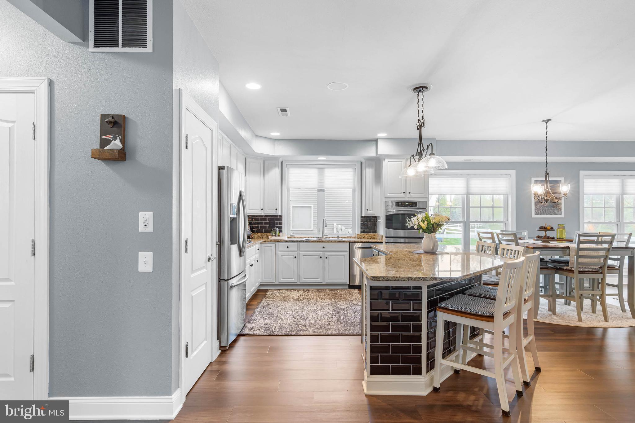 20718 Annondell Drive Lewes, DE 19958 - Photo 8 of 46 a kitchen with stainless steel appliances a dining table chairs stove and white cabinets