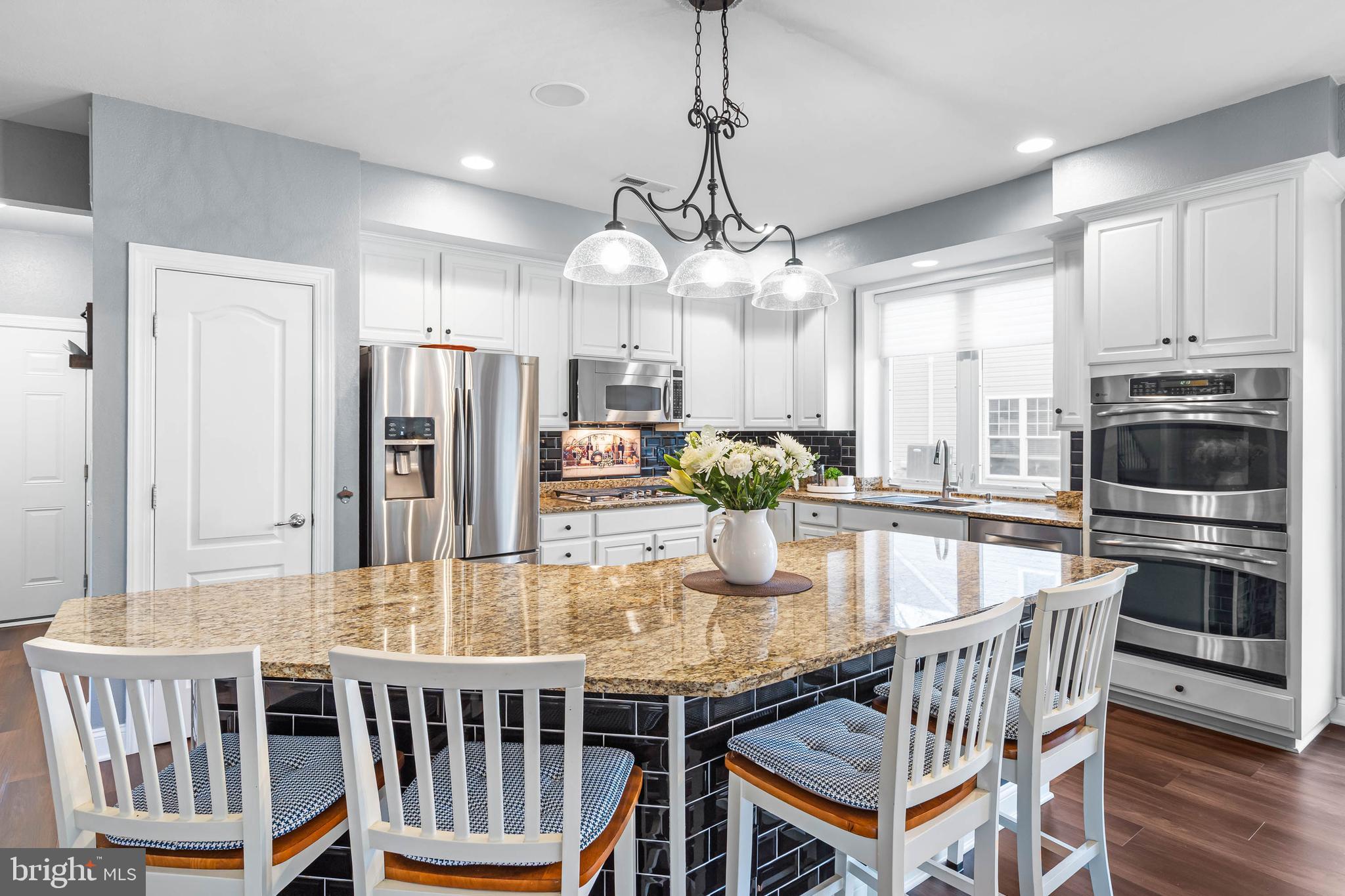20718 Annondell Drive Lewes, DE 19958 - Photo 10 of 46 a kitchen with stainless steel appliances granite countertop a dining table chairs and chandelier