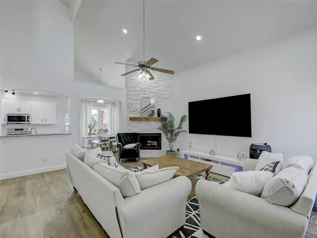 a large kitchen with kitchen island a dining table chairs and white cabinets