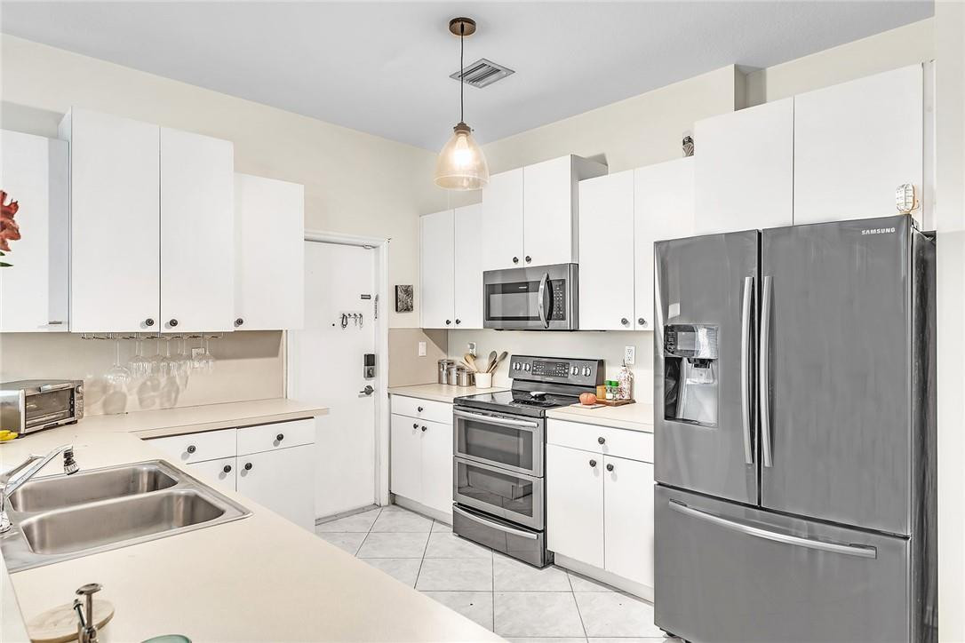 15971 Southwest 96th Terrace Miami, FL 33196 - Photo 21 of 79 a kitchen with stainless steel appliances a refrigerator sink and cabinets