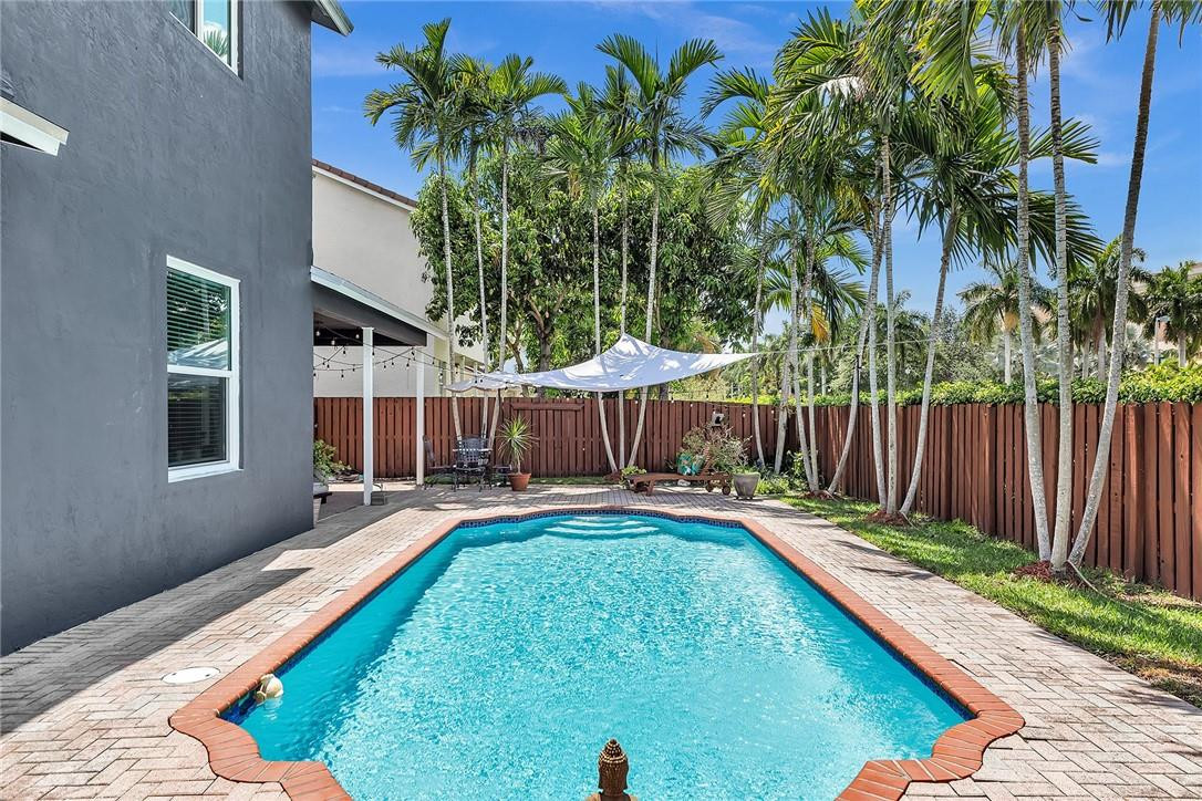 15971 Southwest 96th Terrace Miami, FL 33196 - Photo 50 of 79 a swimming pool with wooden fence