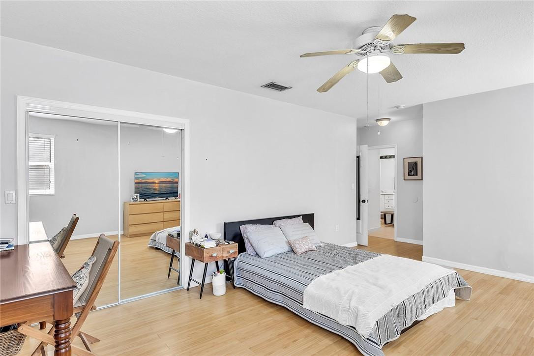 15971 Southwest 96th Terrace Miami, FL 33196 - Photo 55 of 79 a spacious bedroom with a bed and a chandelier