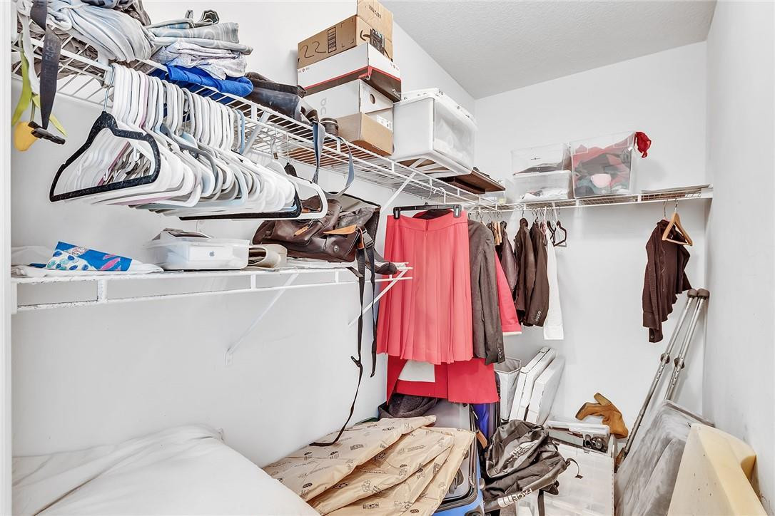 15971 Southwest 96th Terrace Miami, FL 33196 - Photo 58 of 79 a view of walk in closet with clothes and shoes