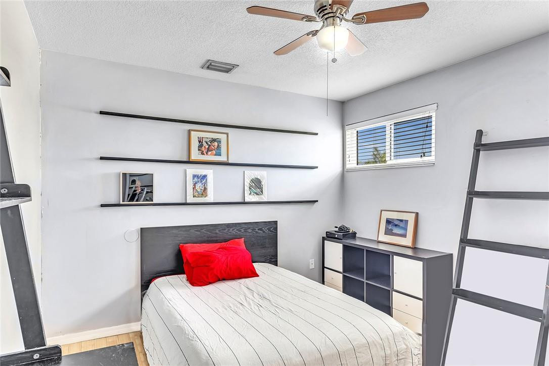 15971 Southwest 96th Terrace Miami, FL 33196 - Photo 67 of 79 a bedroom with a bed and a bookshelf