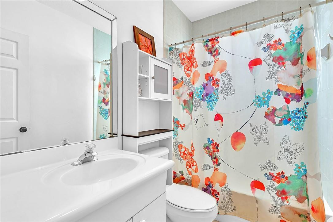 15971 Southwest 96th Terrace Miami, FL 33196 - Photo 73 of 79 a bathroom with a sink a toilet and shower curtain
