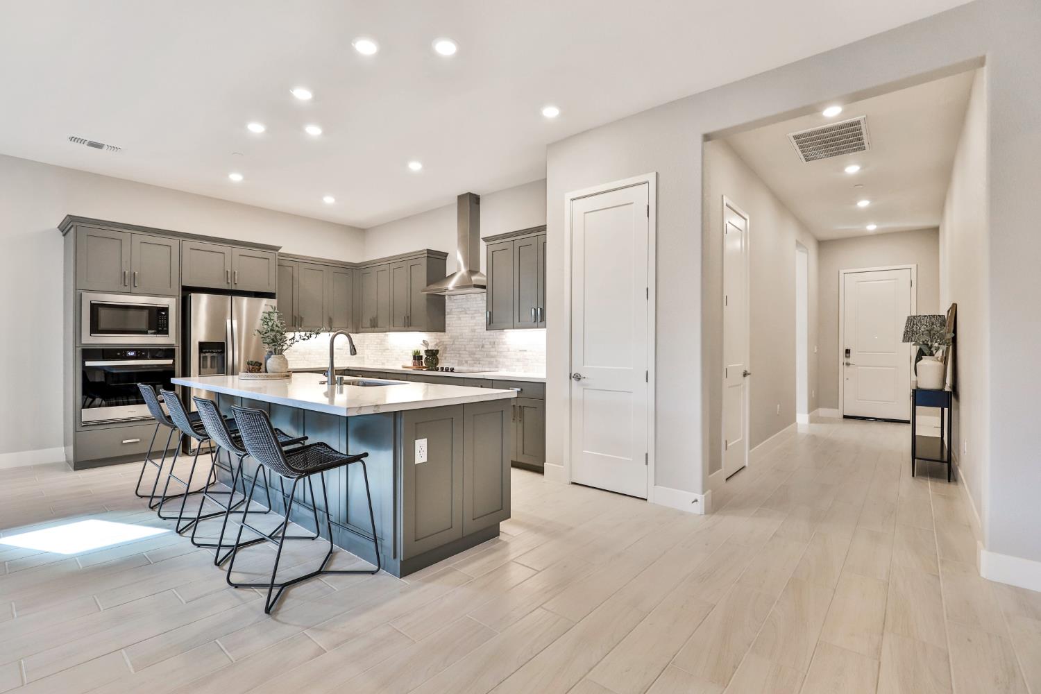 4610 Clb Vista Way Penryn, CA 95663 - Photo 5 of 27 a kitchen with stainless steel appliances kitchen island granite countertop a refrigerator and a sink