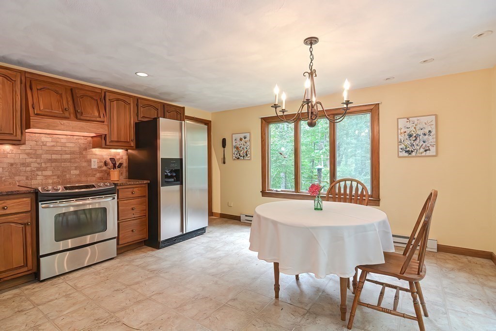 202 Boxboro Road Stow, MA 01775 - Photo 12 of 40 a dining room with wooden floor a chandelier a wooden table and chairs