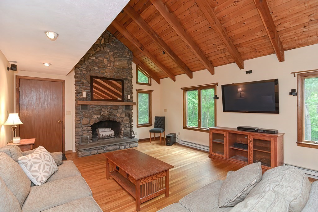 202 Boxboro Road Stow, MA 01775 - Photo 17 of 40 a living room with furniture a flat screen tv and a fireplace