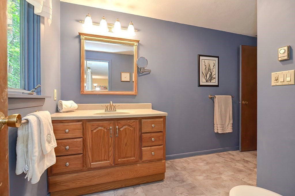 202 Boxboro Road Stow, MA 01775 - Photo 23 of 40 a bathroom with a granite countertop sink a mirror and a vanity