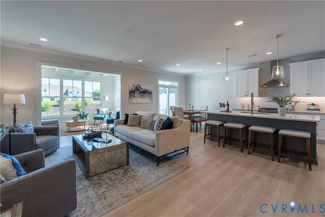 a living room with furniture kitchen view and a large window