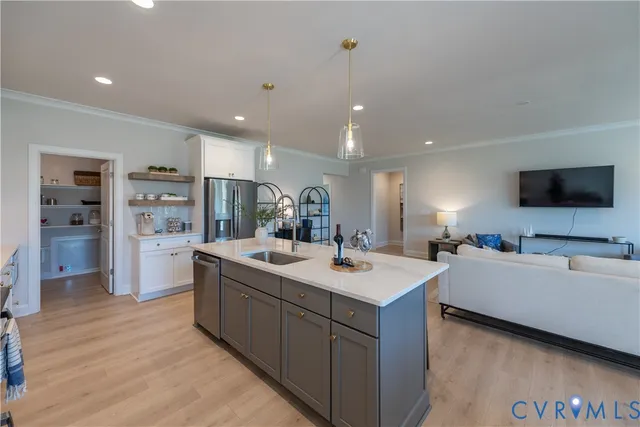 a large room with kitchen island a sink a counter space and stainless steel appliances