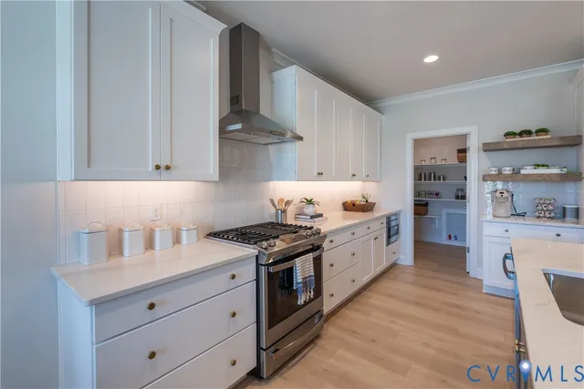 a kitchen with granite countertop white cabinets and white stainless steel appliances