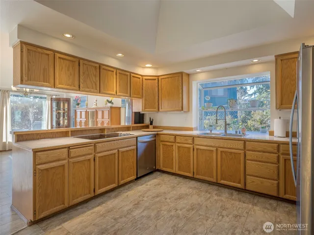 a kitchen with stainless steel appliances granite countertop a refrigerator and a sink