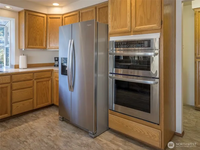 a kitchen that has a lot of cabinets in it and wooden floors
