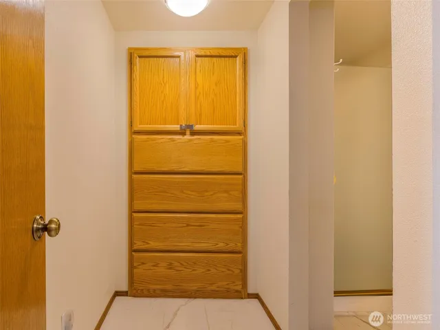 a white toilet sitting next to a white wall