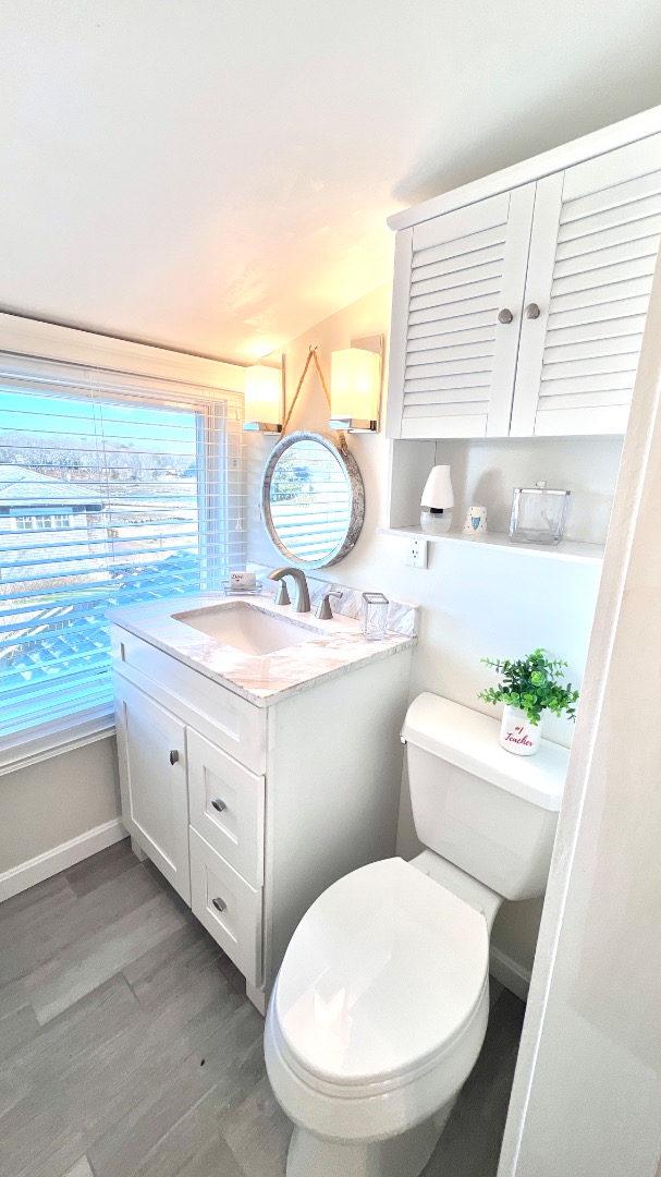34 Windemere Road Oak Bluffs, MA 02557 - Photo 43 of 64 a bathroom with a granite countertop toilet sink and mirror