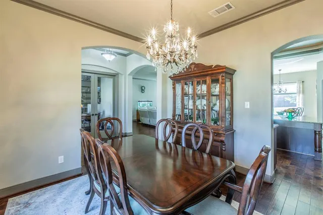 a view of a dining room with furniture a chandelier and wooden floor