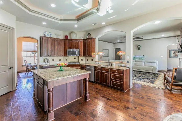 a kitchen with a stove sink cabinets and wooden floor