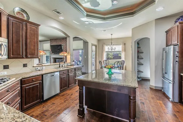 a kitchen with stainless steel appliances granite countertop a stove refrigerator and cabinets