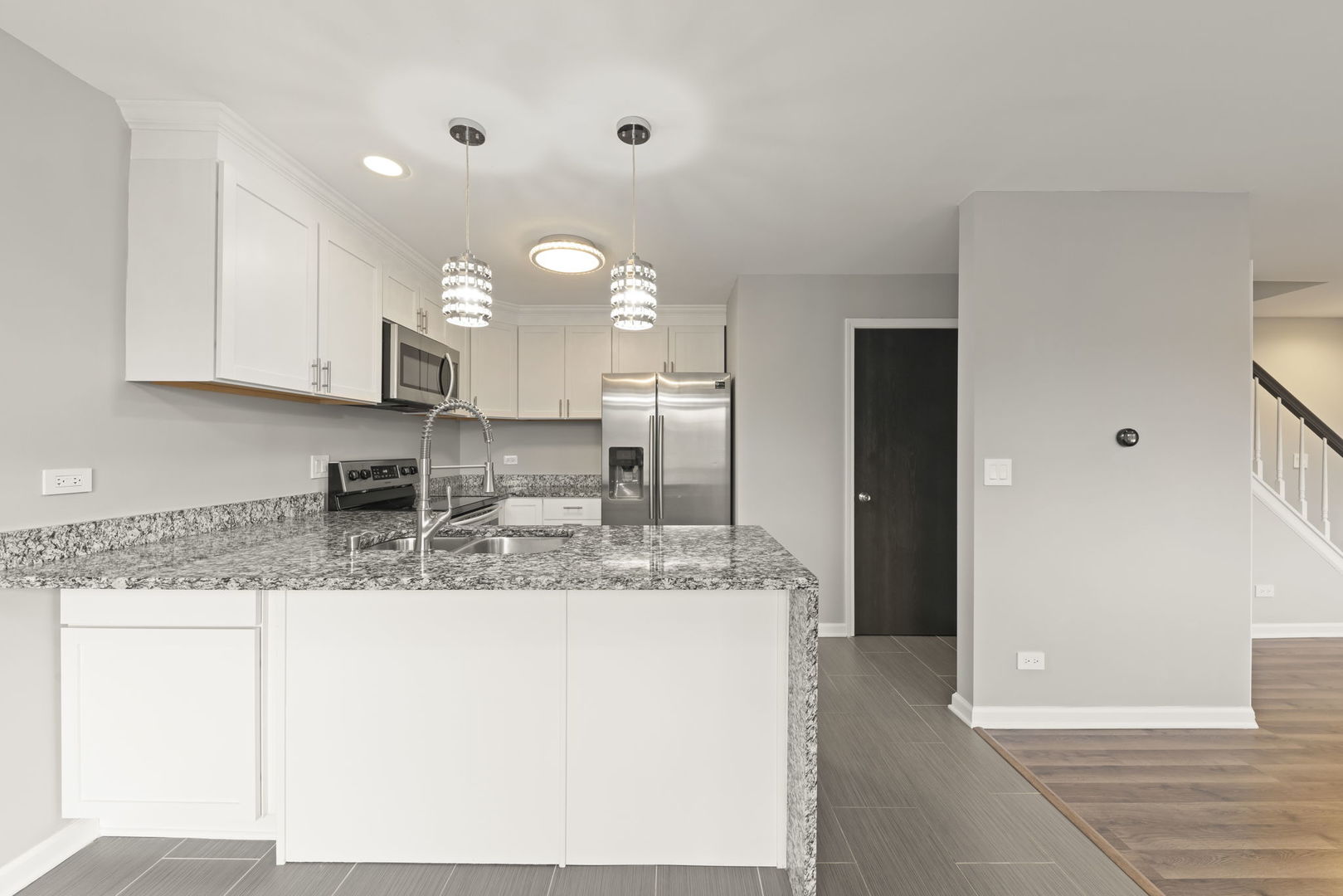 1344 South Lorraine Road, Unit E Wheaton, IL 60189 - Photo 4 of 26 a kitchen with kitchen island granite countertop a sink cabinets and stainless steel appliances