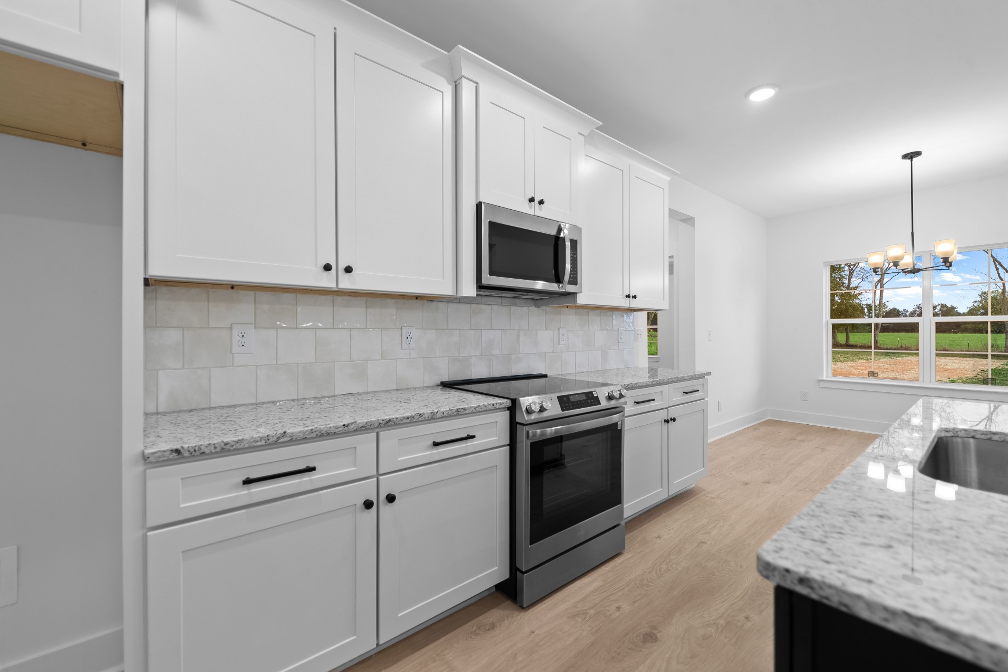 232 Dugout Road Summertown, TN 38483 - Photo 40 of 64 a kitchen with granite countertop white cabinets and stainless steel appliances