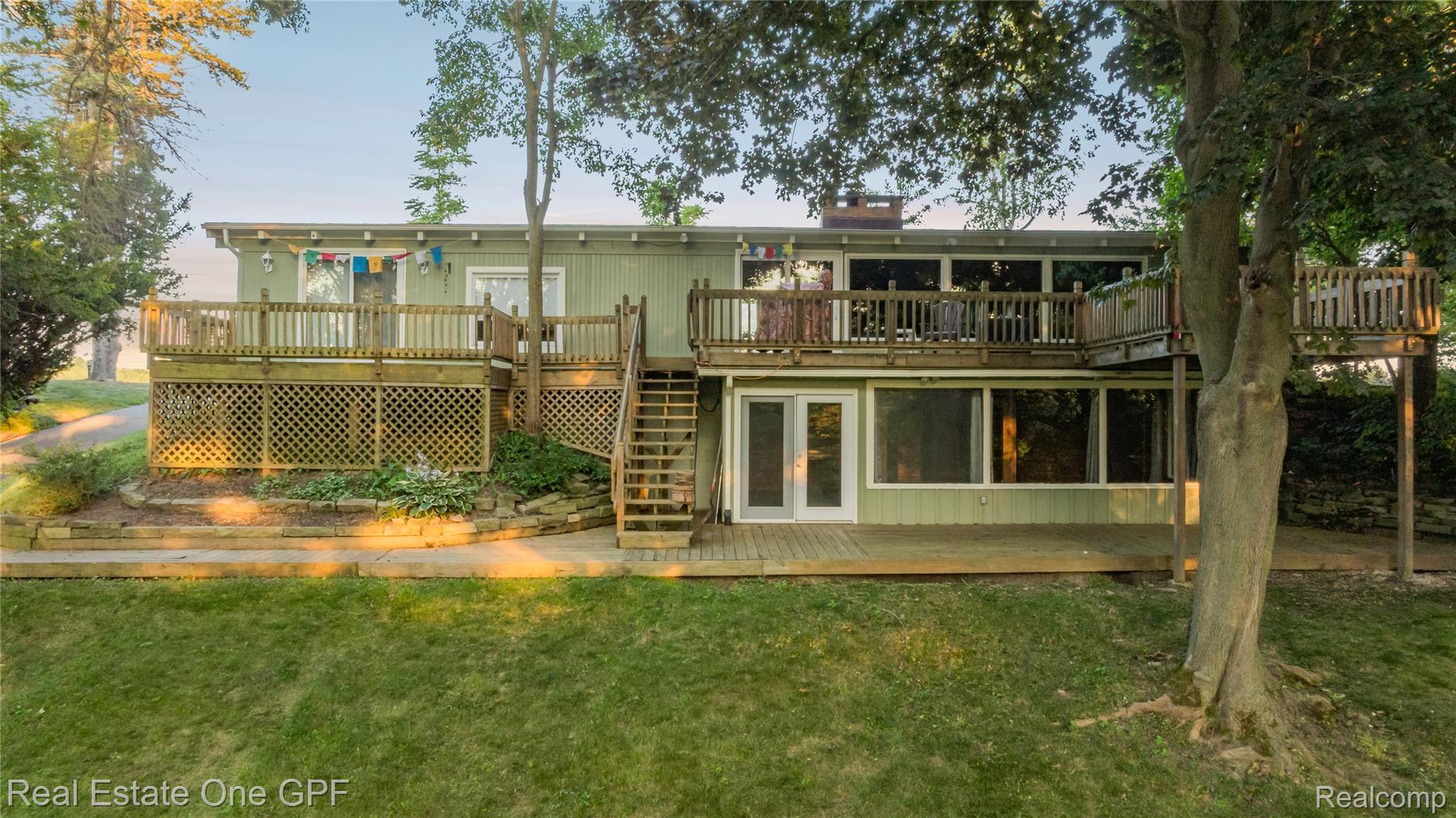 5068 Atkins Road North Street, MI 48049 - Photo 2 of 78 Two-story exterior with two elevated wooden decks, a ground-level wooden patio, and extensive glazing