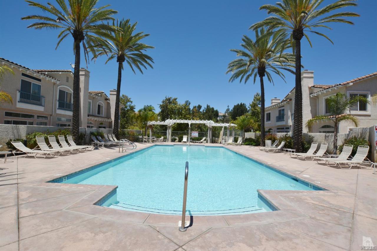 11621 Countrysprings Court, Unit 16 Moorpark, CA 93021 - Photo 14 of 14 a view of a swimming pool with a chair and palm trees
