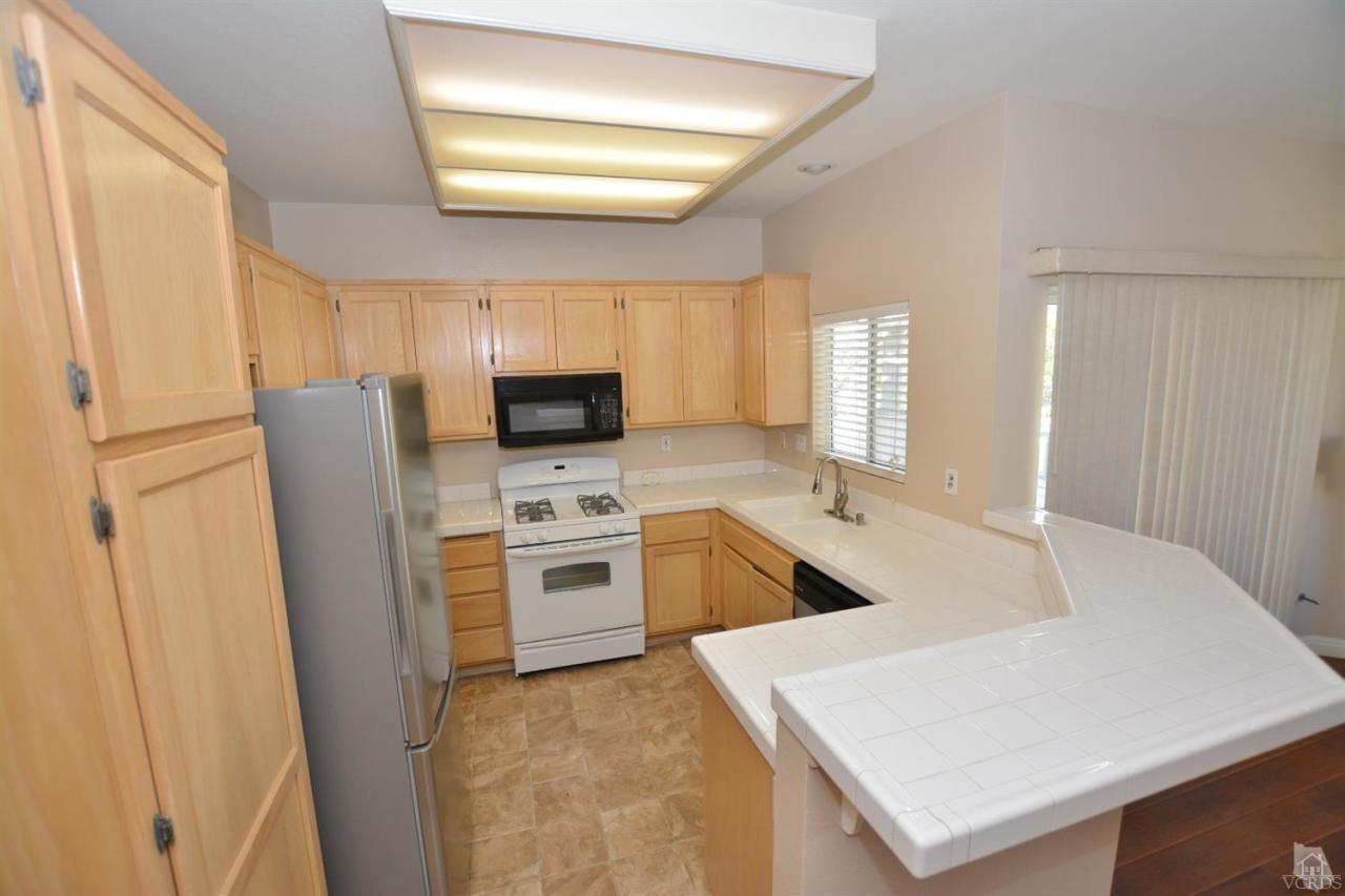 11621 Countrysprings Court, Unit 16 Moorpark, CA 93021 - Photo 3 of 14 a kitchen with stainless steel appliances a stove a sink and a refrigerator