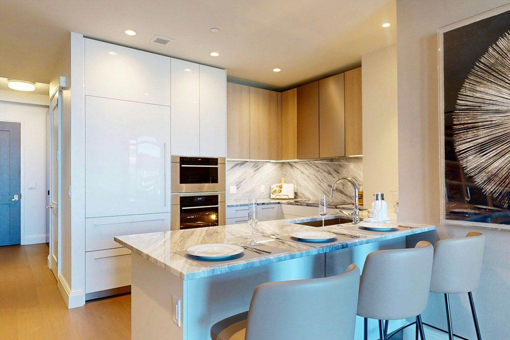 240 Devonshire Street, Unit 4210 Boston, MA 02110 - Photo 2 of 39 a kitchen with kitchen island stainless steel appliances a stove a sink and a refrigerator