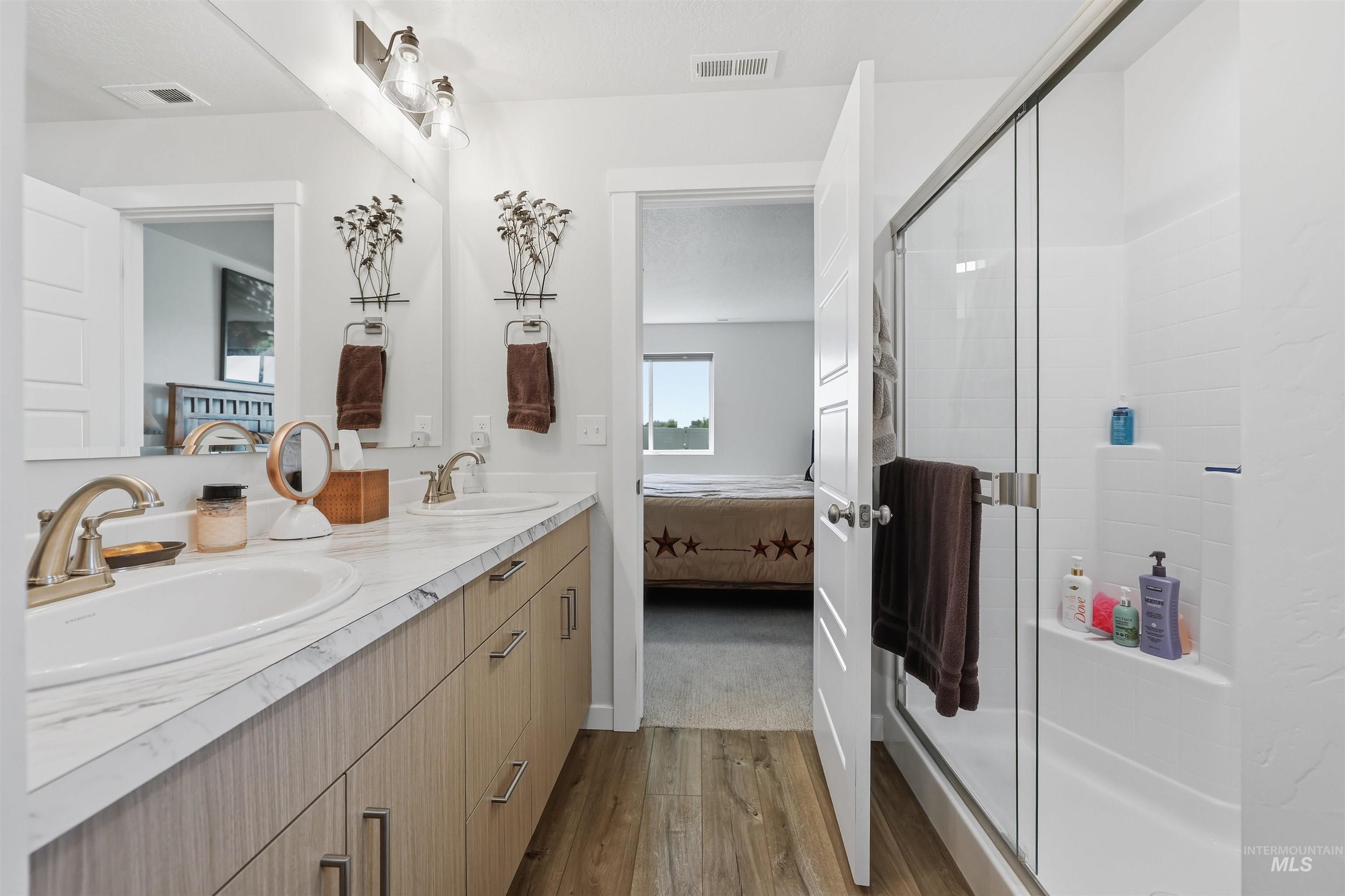 3811 West Maypearl Street Meridian, ID 83642 - Photo 27 of 39 Bathroom featuring a dual vanity with wood-finish cabinetry, white countertops, and undermount sinks