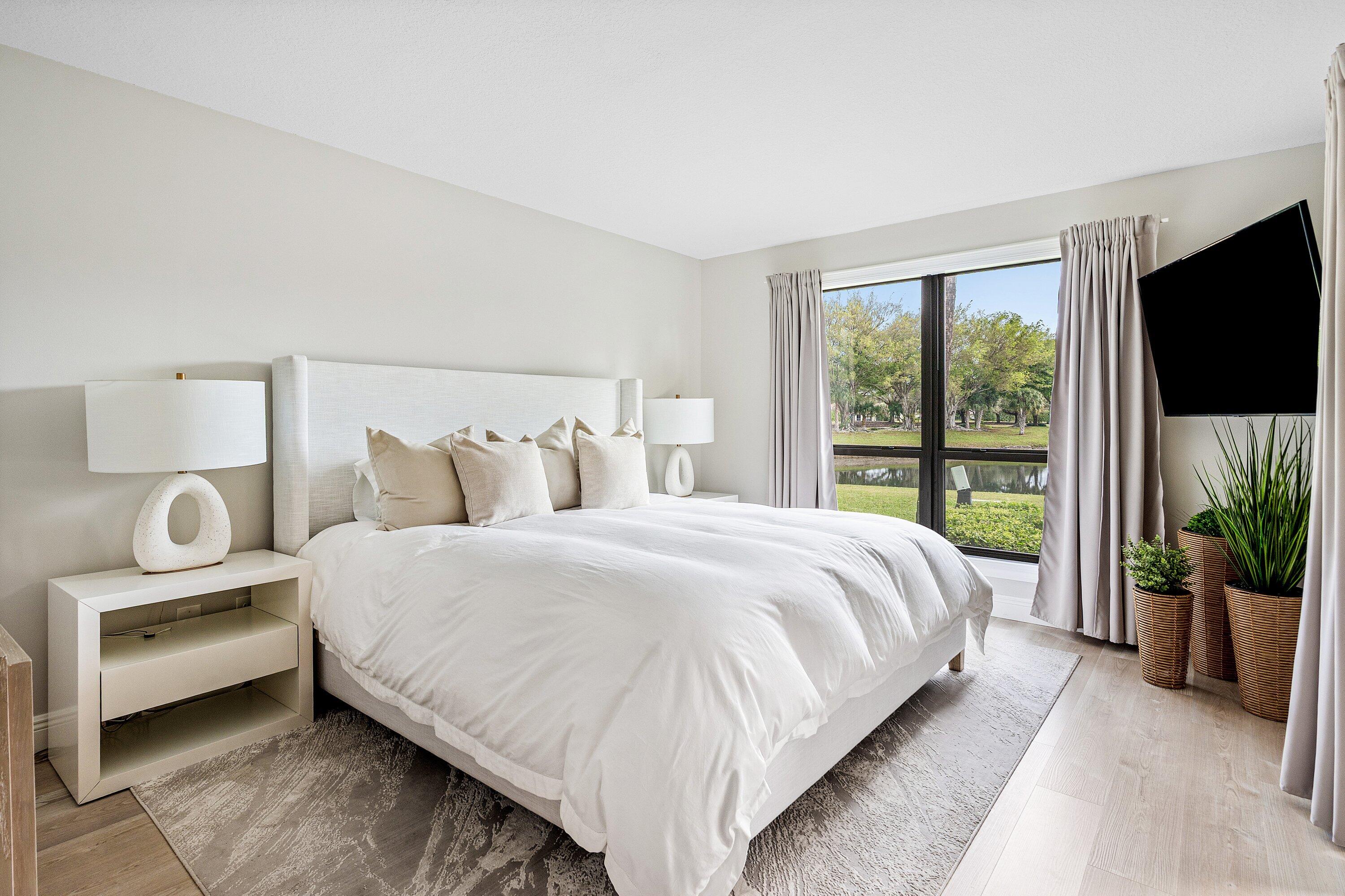 7918 Granada Place, Unit 103 Boca Raton, FL 33433 - Photo 13 of 31 a bedroom with bed and a flat tv screen on dresser