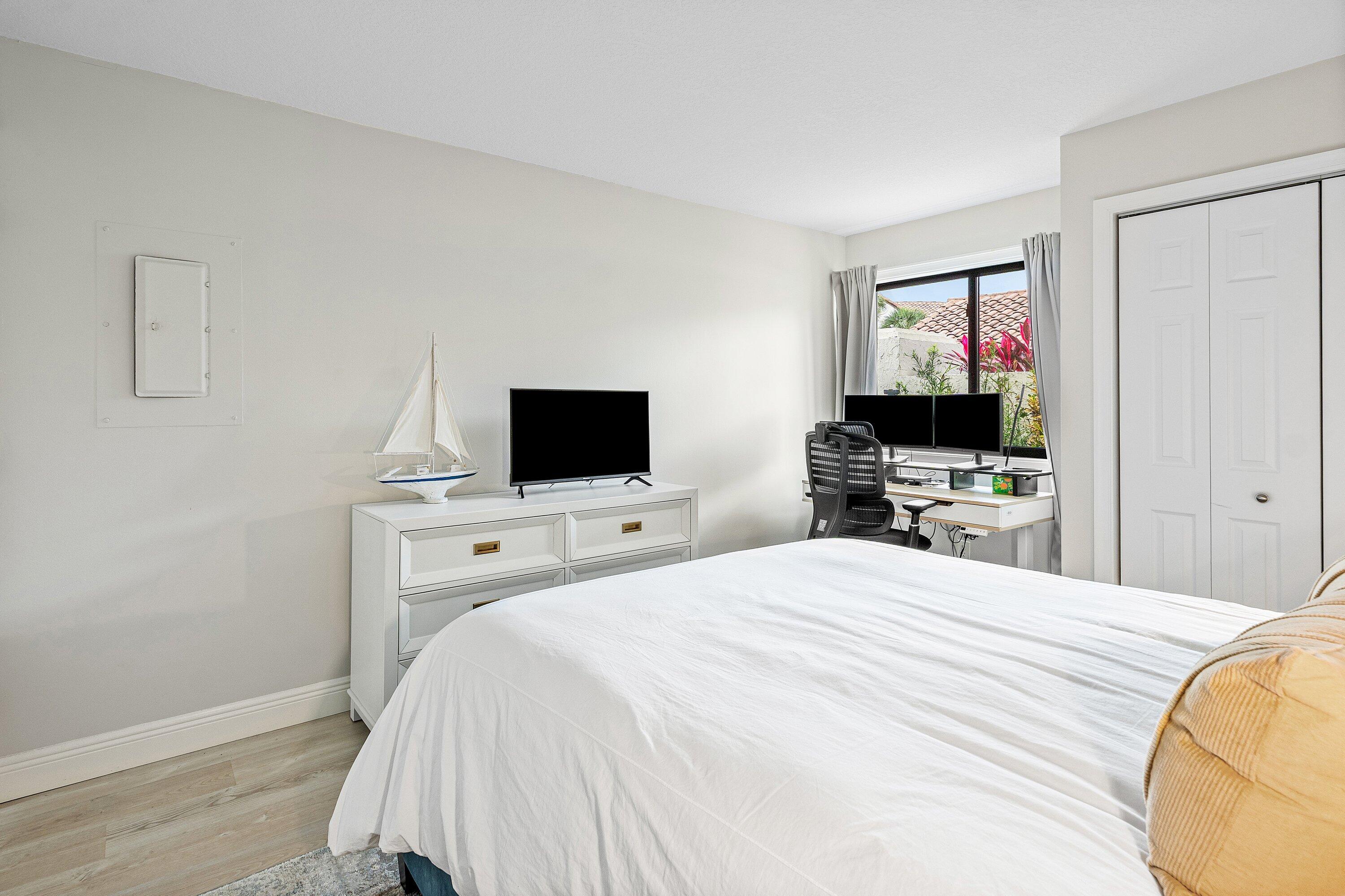 7918 Granada Place, Unit 103 Boca Raton, FL 33433 - Photo 18 of 31 a bedroom with a bed and a flat screen tv