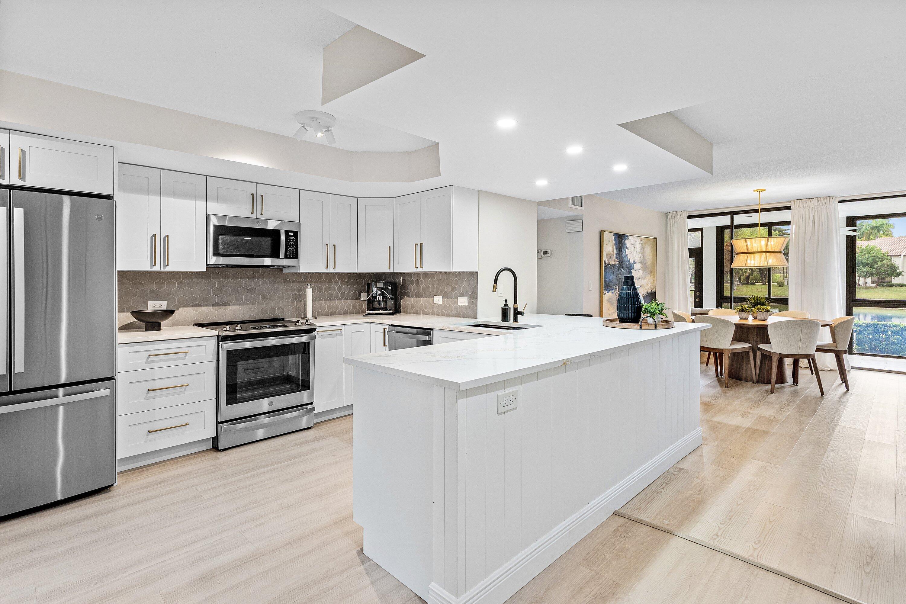7918 Granada Place, Unit 103 Boca Raton, FL 33433 - Photo 2 of 31 a kitchen with cabinets and stainless steel appliances