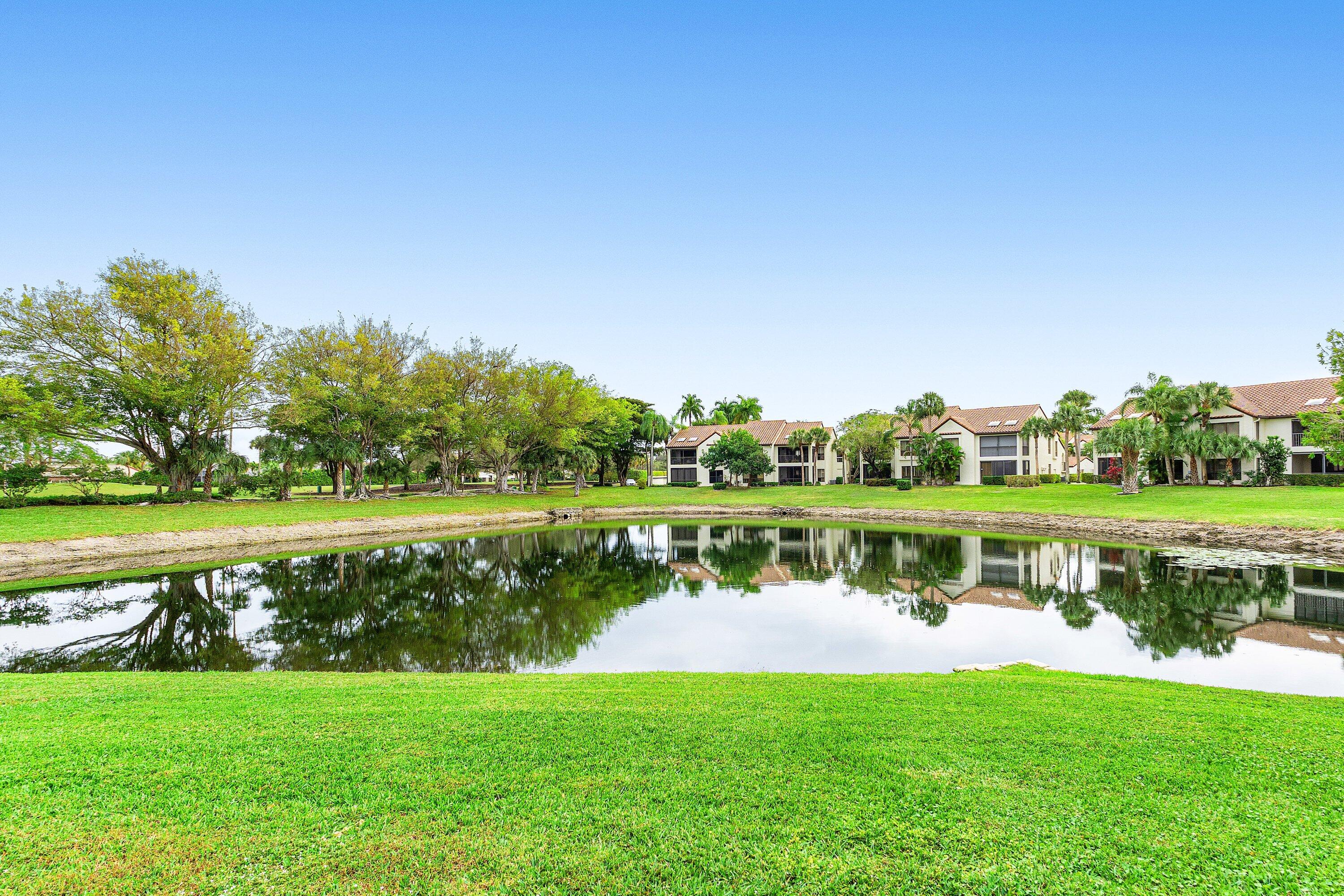 7918 Granada Place, Unit 103 Boca Raton, FL 33433 - Photo 24 of 31 a view of a lake with a yard and a large trees