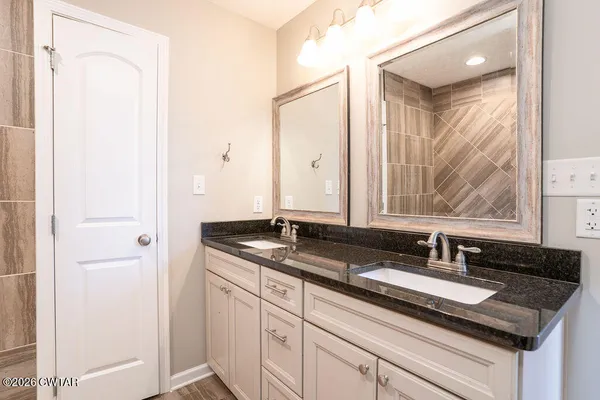 a bathroom with a granite countertop sink and a mirror