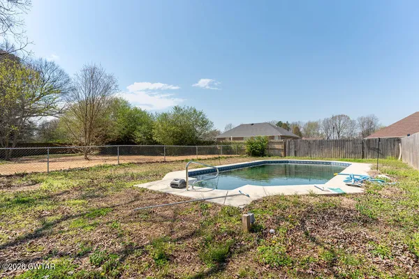 a view of a backyard with swimming pool