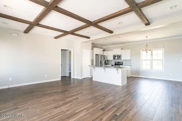 a view of a kitchen with wooden floor and a refrigerator