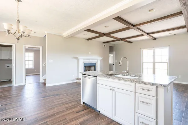 a kitchen with a sink cabinets and wooden floor
