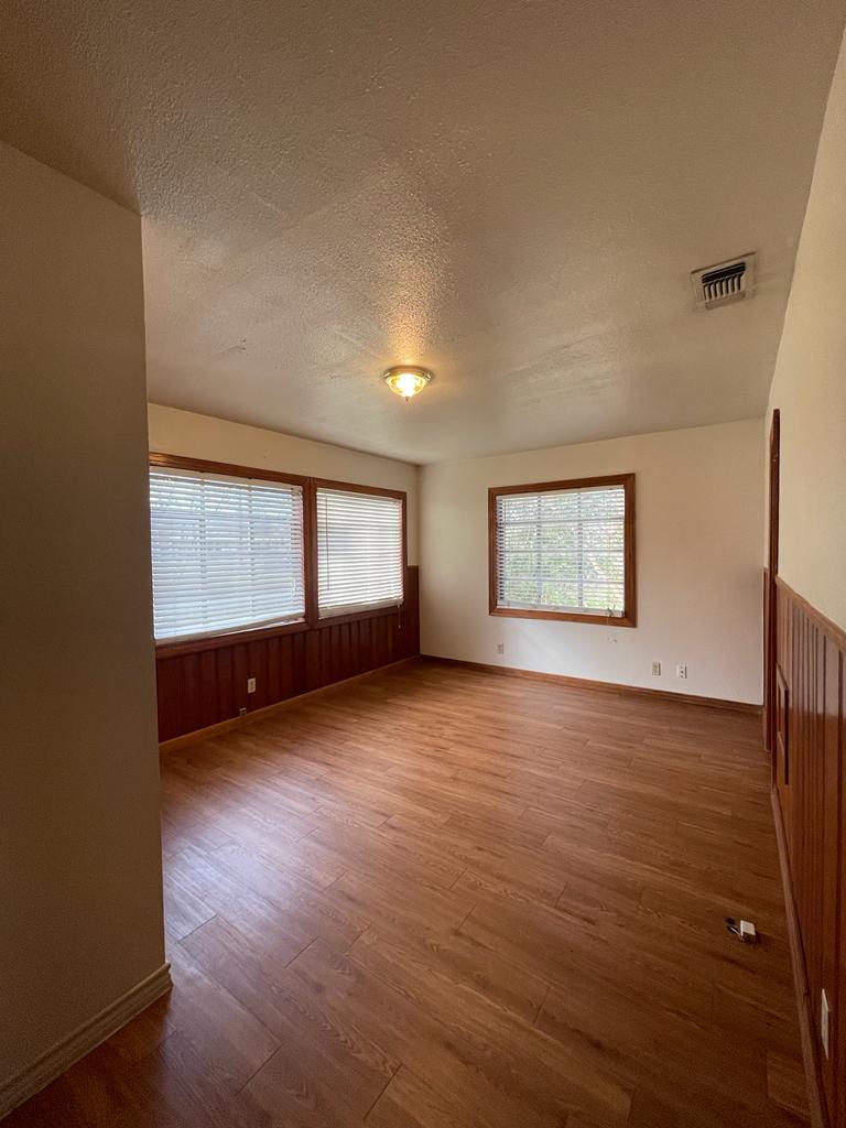 108 Austin Street, Unit B Kyle, TX 78640 - Photo 12 of 14 Natural light filters through multiple windows, illuminating the durable laminate flooring in this versatile space.