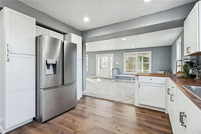 a kitchen with stainless steel appliances granite countertop a refrigerator a sink and a stove